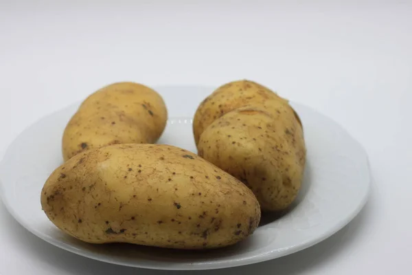 raw white potatoes on white background