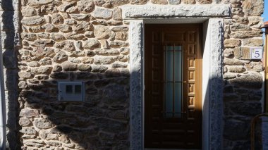 Taş duvar ve ahşap kapı.