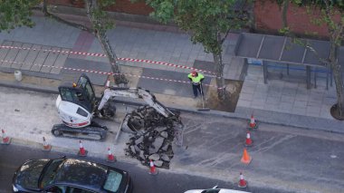 Madrid, İspanya, 7 Eylül 2020: Covid-19 salgını sırasında Madrid caddesinde bir inşaat alanında buldozer ve işçi.