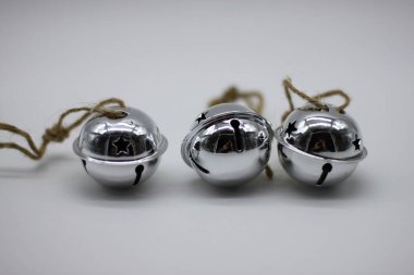 Beyaz arka planda asılı duran gümüş çanlar. Yeni yıl ve Noel için dekorasyon. Yeni yıl konsepti. Noel tasarımları için unsurlar. Noel, yeni yıl.