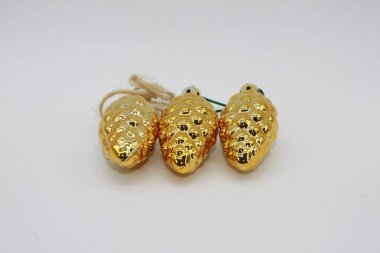 Beyaz arka planda üç altın renkli kozalak. Noel süslemeleri. Noel süslemeleri.