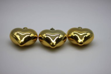 Beyaz arka planda üç altın kalp Noel süslemeleri Noel süslemeleri