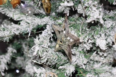 Karlı köknar dallarındaki altın Noel süslemelerinin arka planı. Noel süsü. Yeni yıl ve Noel konsepti.