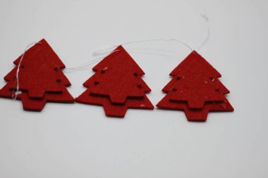 Beyaz arka planda izole edilmiş kırmızı Noel ağacı şekilli mücevherler. Noel süslemesi. Yeni yıl ve Noel konsepti