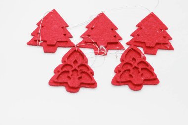 Beyaz arka planda izole edilmiş kırmızı Noel ağacı şekilli mücevherler. Noel süslemesi. Yeni yıl ve Noel konsepti