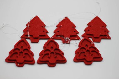 Beyaz arka planda izole edilmiş kırmızı Noel ağacı şekilli mücevherler. Noel süslemesi. Yeni yıl ve Noel konsepti