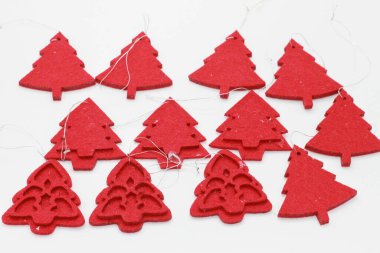 Beyaz arka planda izole edilmiş kırmızı Noel ağacı şekilli mücevherler. Noel süslemesi. Yeni yıl ve Noel konsepti