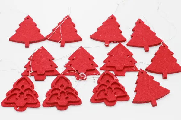 Beyaz arka planda izole edilmiş kırmızı Noel ağacı şekilli mücevherler. Noel süslemesi. Yeni yıl ve Noel konsepti