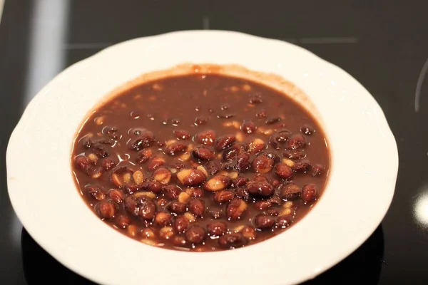 赤豆を煮込み白い皿に盛り — ストック写真