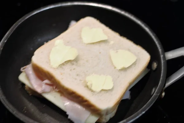 Приготовление Сэндвича Ветчиной Сыром Маслом Черной Сковороде — стоковое фото