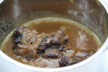 Metal bir tencerede pişirilmiş sığır kuyruğu güveci.