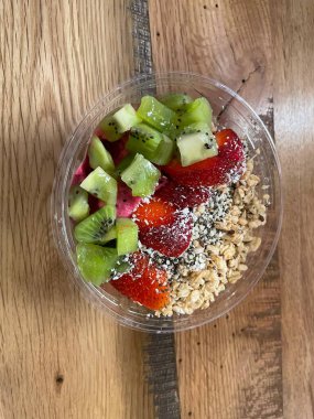 Ejder meyveli meyve suyu kasesi kivi, çilek ve granola ile.