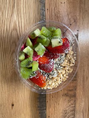 Ejder meyveli meyve suyu kasesi kivi, çilek ve granola ile.