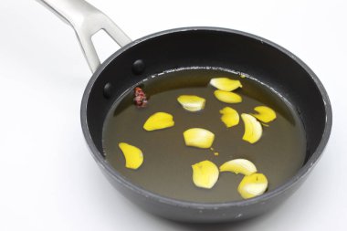 Zeytinyağlı bir tavada sarımsak ve biber.