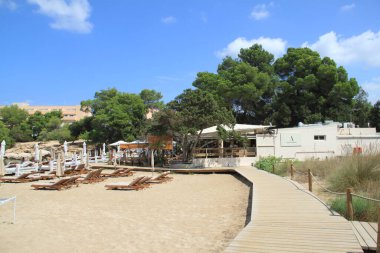 Es Port D 'Es Torrent, Ibiza, Balearic Adaları, İspanya, 30 Ağustos 2021: Plajda güneşli bir gün geçiren turistler ve İbiza' daki Port d 'Es Torrent Plaj Kulübü