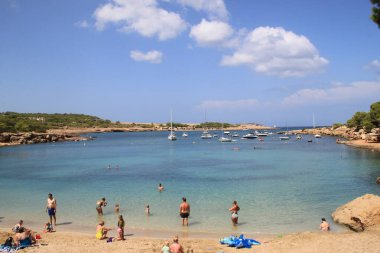 Es Port D 'Es Torrent, Ibiza, Balearic Adaları, İspanya, 30 Ağustos 2021: Plajda güneşli bir gün geçiren turistler ve İbiza' daki Port d 'Es Torrent Plaj Kulübü