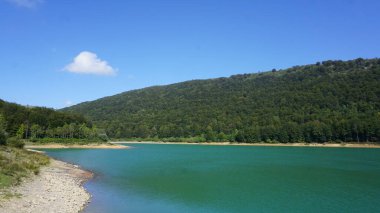 İspanya 'nın Bask Bölgesi' nde Gipuzkoa 'daki Sierra de Aralar' da güneşli bir günde Lareo rezervuarının mavi sularının manzarası. Doğal boşluklar.