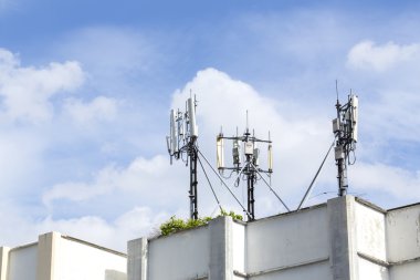 Cep telefonu kuleleri mavi gökyüzü ile Resident binanın çatısında