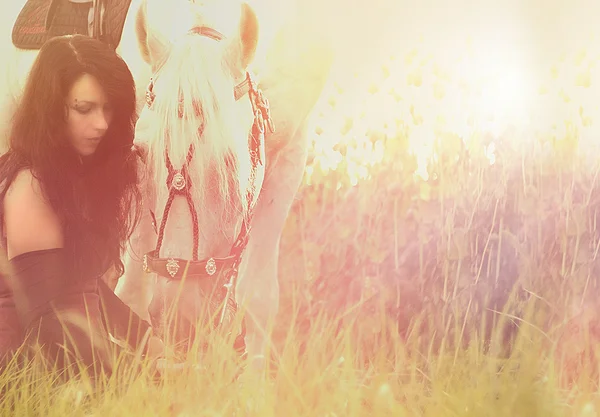 Jovem mulher montando e abraço com cavalo ao pôr do sol — Fotografia de Stock