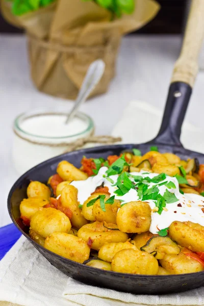 Gnocchi with zucchini, tomatoes and feta dip, selective focus — Stock Photo, Image