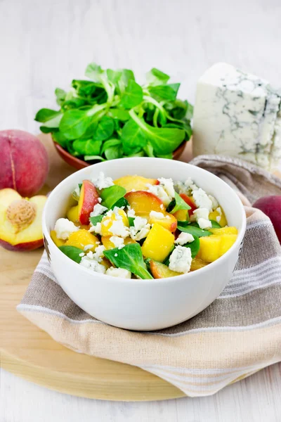 Green salad with grilled peaches, gorgonzola cheese and corn salad leaves, selective focus