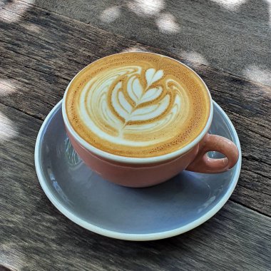 Ahşap arka planda bir kupa kahvenin üst görüntüsü. 