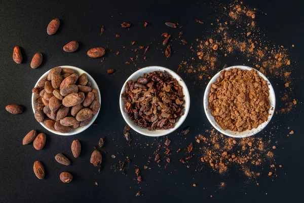 Cacao beans seeds, Cacao nibs and cacao powder isolated on black background.