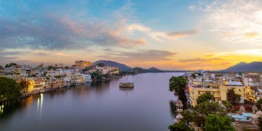 Udaipur şehri, Pichola Gölü, Rajasthan, Hindistan. Şehir sarayının manzarası göle yansıyor.