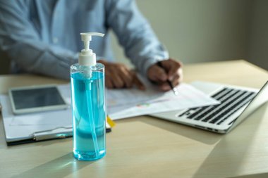 Ev hapsinde çalışan bir adam antiseptik jel sosyal mesafe covid-19 aşısı Coronavirüs kullanıyor.