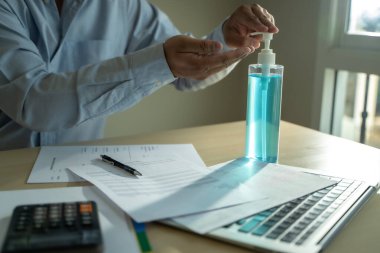 Ev hapsinde çalışan bir adam antiseptik jel sosyal mesafe covid-19 aşısı kullanarak Coronavirüs 19 Coronavirus sağlık hizmetini kazanacağız.