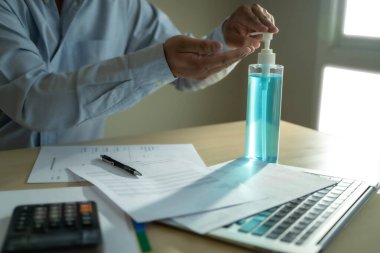 Ev hapsinde çalışan bir adam antiseptik jel sosyal mesafe covid-19 aşısı kullanarak Coronavirüs 19 Coronavirus sağlık hizmetini kazanacağız.