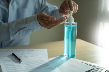 Ev hapsinde çalışan bir adam antiseptik jel sosyal mesafe covid-19 aşısı kullanarak Coronavirüs 19 Coronavirus sağlık hizmetini kazanacağız.