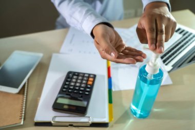 Ev hapsinde çalışan bir adam antiseptik jel sosyal mesafe covid-19 aşısı kullanarak Coronavirüs 19 Coronavirus sağlık hizmetini kazanacağız.