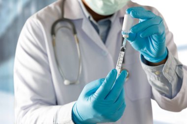 COVID-19 Aşı, doktorun elinde şırınga ve şişe korona virüsü aşısı var