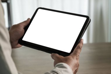 Adam ofisinde bir maket düzenliyor. Boş ekranlı iPad dijital tableti ofisteki tasarım modelinizin yerini alır.