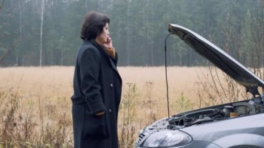 Kırsal kesimdeki bir kadın bozuk arabası için yardım almaya çalışıyor ve tahliye ya da acil durum çağrısı yapıyor.