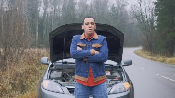 Homem no fundo de um carro avariado. Motorista masculino estressado em pé na frente do capô aberto. Quebra, problema. — Vídeo de Stock