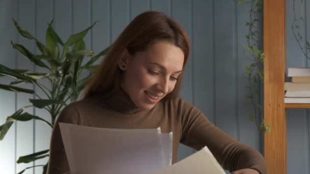 机に座っている女性は手紙の中で素晴らしい肯定的なニュースを読む幸せな気分 — ストック動画