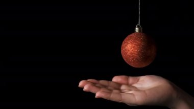 Koyu, soyutlanmış Whit kadınlarının elinde kırmızı Noel topları