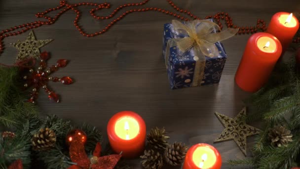 Weihnachtsgeschenk, Blick von oben nach unten. Weibliche Hände legen eine Schachtel mit einem Geschenk auf einen Tisch, der mit Zweigen eines Weihnachtsbaums geschmückt ist. Neujahrsgeschenke. — Stockvideo