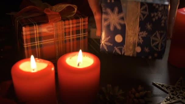 Женщина кладет подарок на стол, украшенный рождественскими украшениями. Концепция Рождества и Нового года — стоковое видео