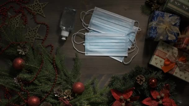 クリスマス、ブルーメディカルフェイスマスクと消毒剤で新年の背景。2020年のコンセプト、自己分離、保護、冬休みの社会的距離 — ストック動画