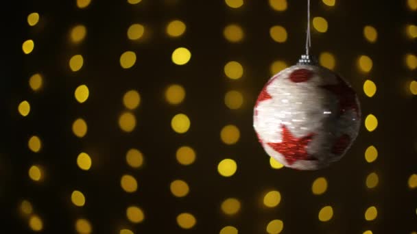 Χριστουγεννιάτικη μπάλα στο φόντο αναβοσβήνει θολή γιρλάντα. — Αρχείο Βίντεο