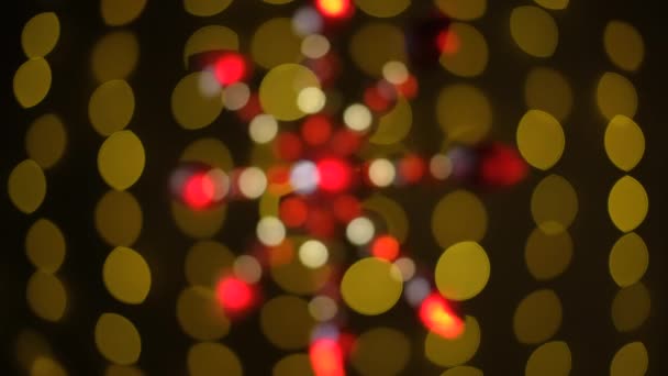 Rode Kerst ster bokeh op een slinger bokeh achtergrond. Bokeh. Veelkleurige sprankelingen, wazige achtergrond. — Stockvideo