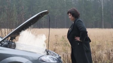 Kadın araba motoruna bakıyor..