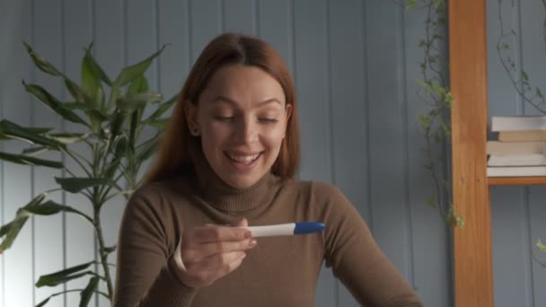 Happy Woman παίρνει ένα τεστ εγκυμοσύνης και είναι έγκυος, εκρήγνυται σε μια στιγμή ευτυχίας και χαράς για τη μελλοντική γέννηση του παιδιού της. Έννοια της: γέννηση, ζωή, οικογένεια. — Αρχείο Βίντεο