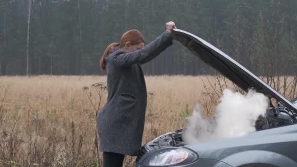 Zakelijke vrouw open de motorkap en kijken naar auto rook motor — Stockvideo