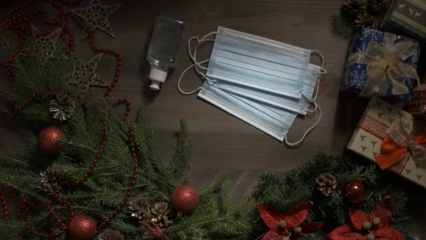 Kerst, Nieuwjaar achtergrond met Blue Medical Face Mask en ontsmettingsmiddel. 2020 jaar concept, zelfisolatie, bescherming, sociale afstand op wintervakantie — Stockvideo