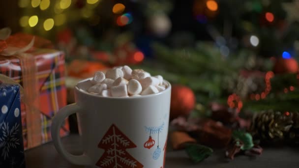 Uma mulher derrama cacau em um copo de marshmallows com cacau. Fundo de Natal — Vídeo de Stock