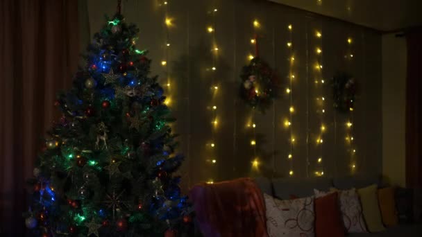 Christmas tree, happy holidays. Christmas interior. beautiful Christmas tree in room, decorated with garland and a star. — Vídeos de Stock